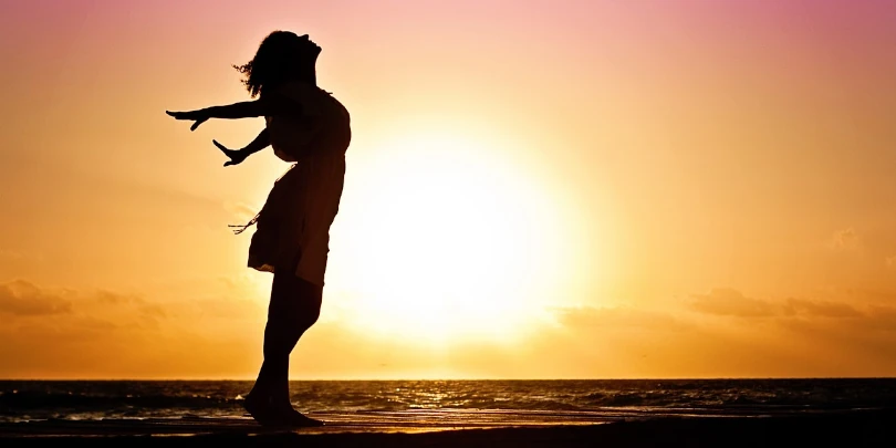 mulher feliz ao por do sol