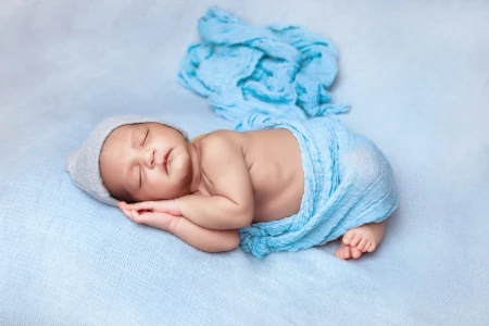 bebe dormindo em colcha azul