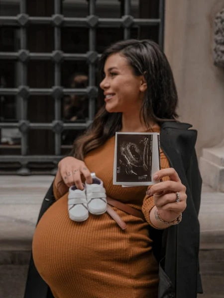 mulher gestante segurando uma ultrasom de um bebe