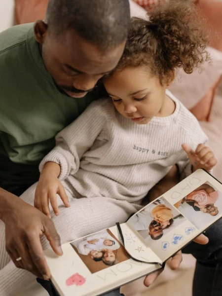 pai mostrando um photobook para a filha