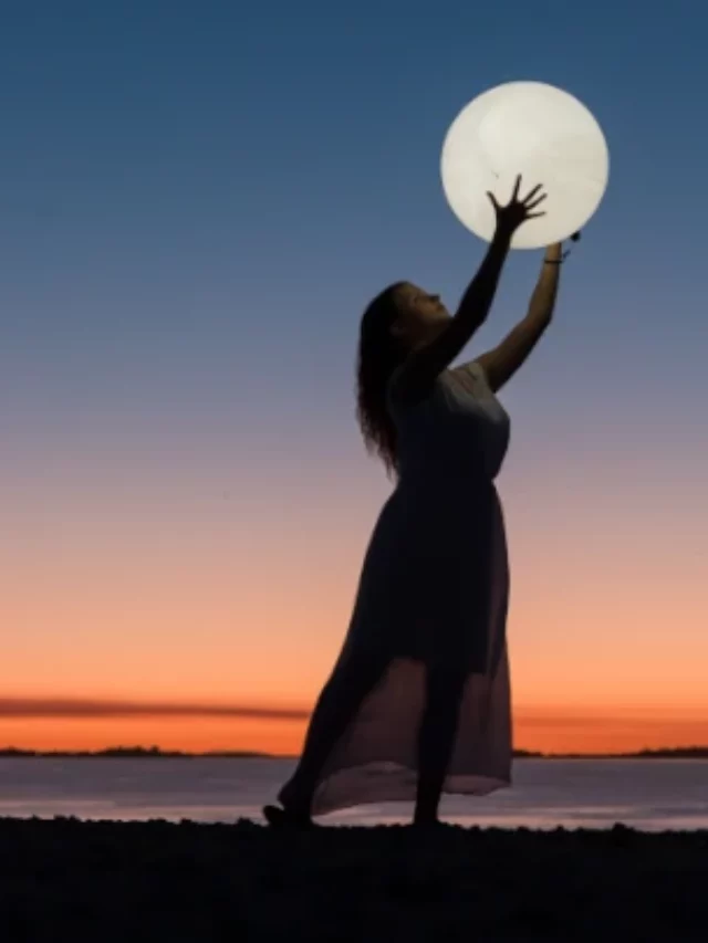 mulher segurando a lua em ângulo baixo