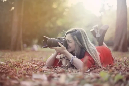 mulher fotografando floresta em ângulo baixo