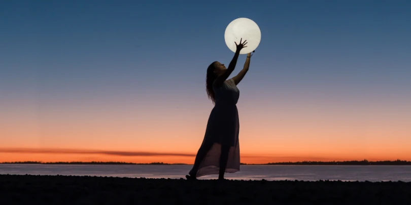 mulher segurando a lua em ângulo baixo