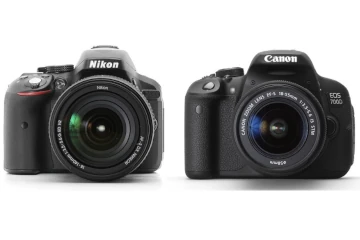 Duas câmeras DSLR lado a lado das marcas Canon e Nikon.