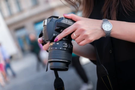 mulher conferindo foto em câmera profissional