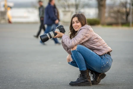 Mulher fotografando na rua sorrindo