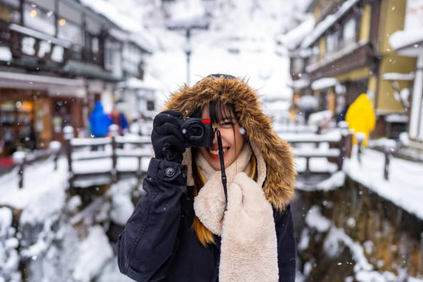 Mulher fotografando na neve
