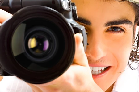 Mulher sorrindo fotografando com câmera profissional