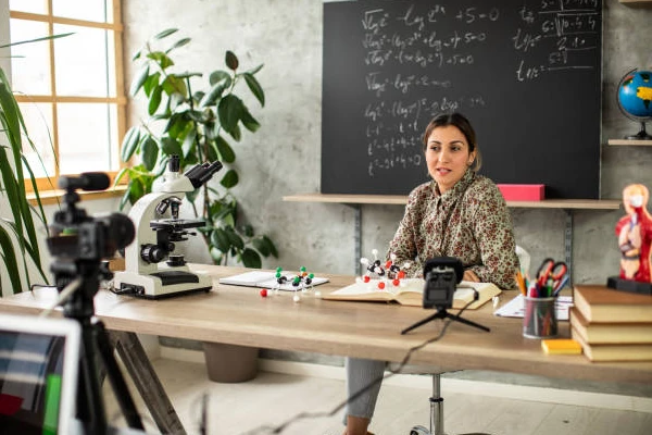 professora gravando vídeo com câmera DSLR e gravador portátil