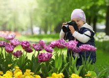 pequeno fotografo fotografando flores primavera
