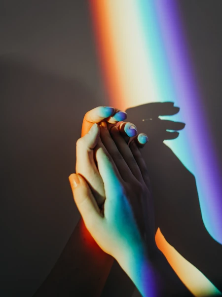 Mãos tocando o arco-íris