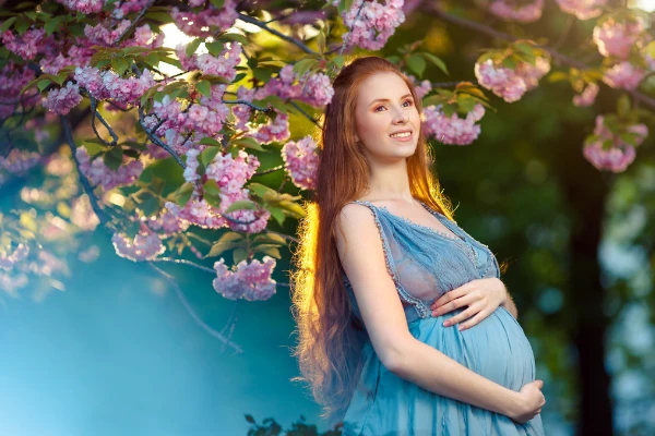 mulher grávida em azul com flores roxas